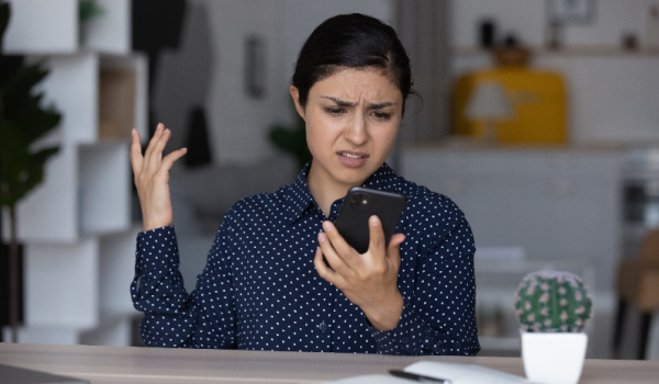 Upset annoyed woman having problems with smartphone