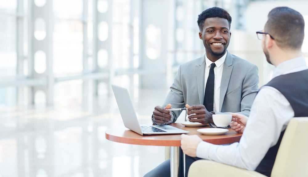 Successful businessman smiling during meeting with colleague at coffee break