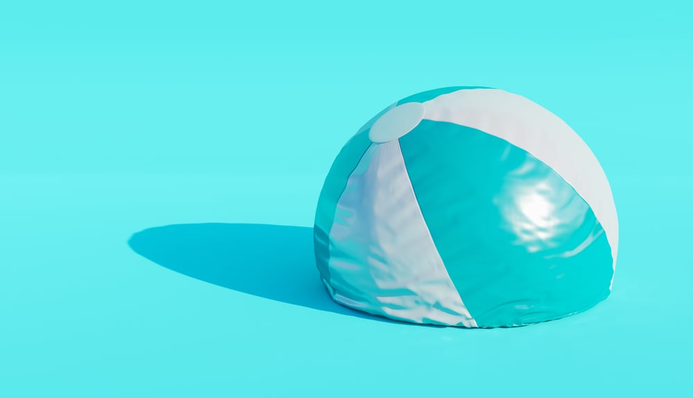 Deflated beach ball on blue background. minimalistic scene. end of summer concept.