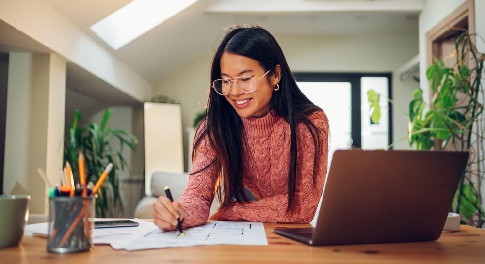 Image of person working in a home office and using a laptop